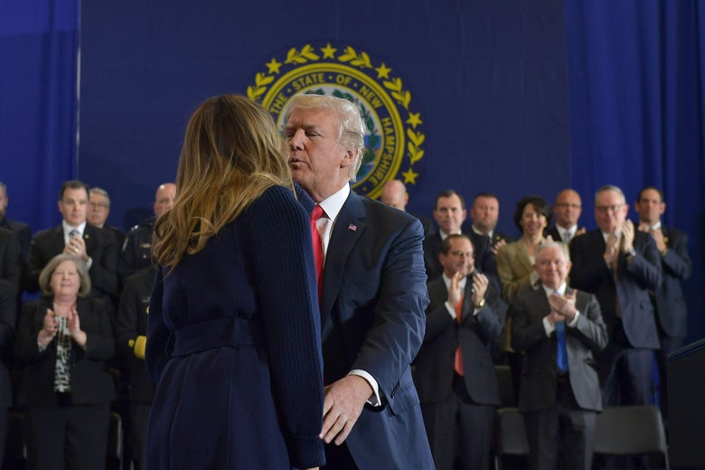 Donald Trump kisses First Lady Melania Trump in front of a group of people clapping.